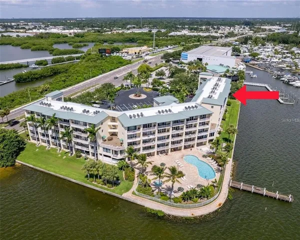 an aerial view of a house with a garden and lake view
