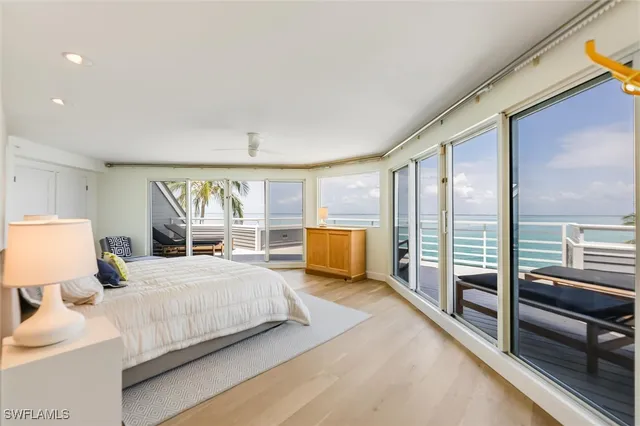 a bedroom with a bed and large windows