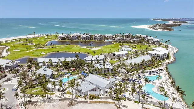 a view of a swimming pool with lawn chairs under an umbrella