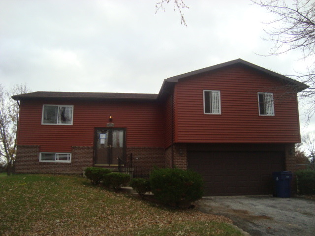 109 Cloverleaf Road Matteson, IL 60443 - Photo 1 of 25 a brick house with a small yard and a large window