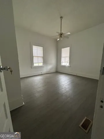 an empty room with windows and cabinet