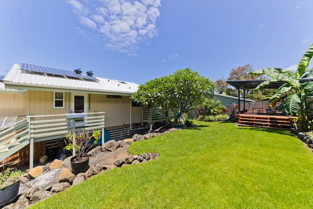 a view of a house with backyard and sitting area