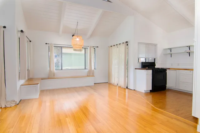a view of a kitchen with wooden floor and a refrigerator