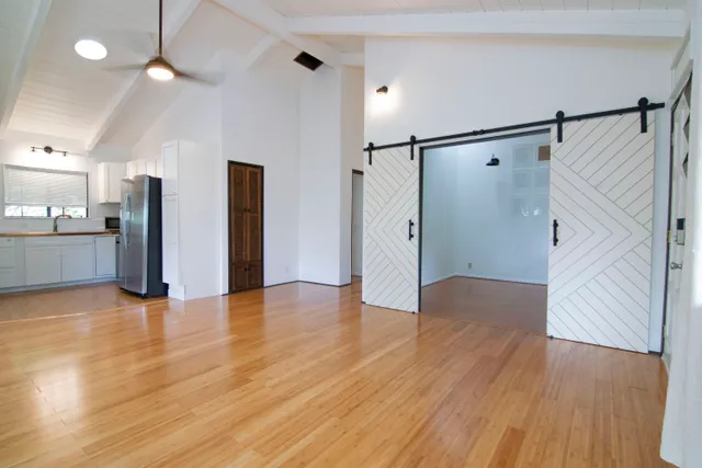 a view of a kitchen with a refrigerator and wooden floor