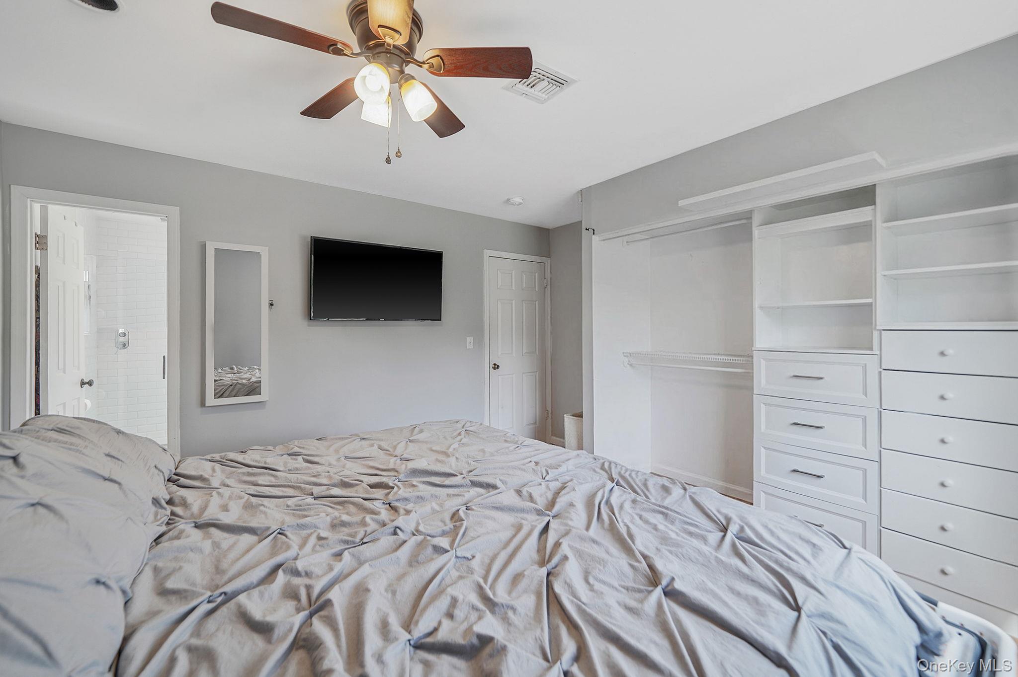 19 Goodwin Lane Coram, NY 11727 - Photo 12 of 36 a bedroom with a bed and a flat tv screen on dresser