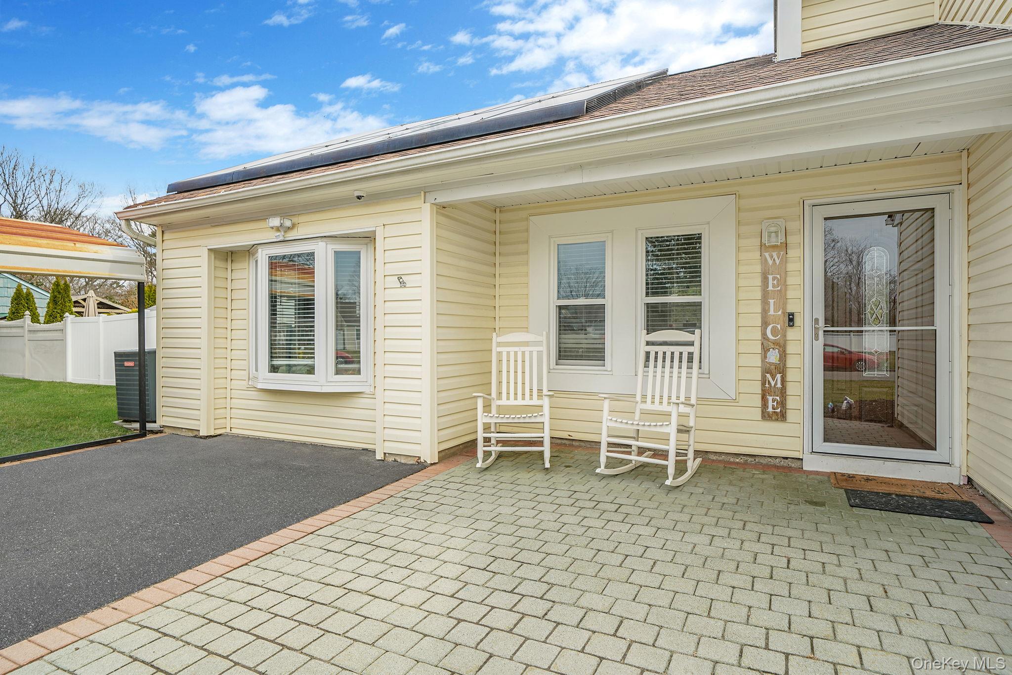 19 Goodwin Lane Coram, NY 11727 - Photo 23 of 36 a porch with a chair and table chair