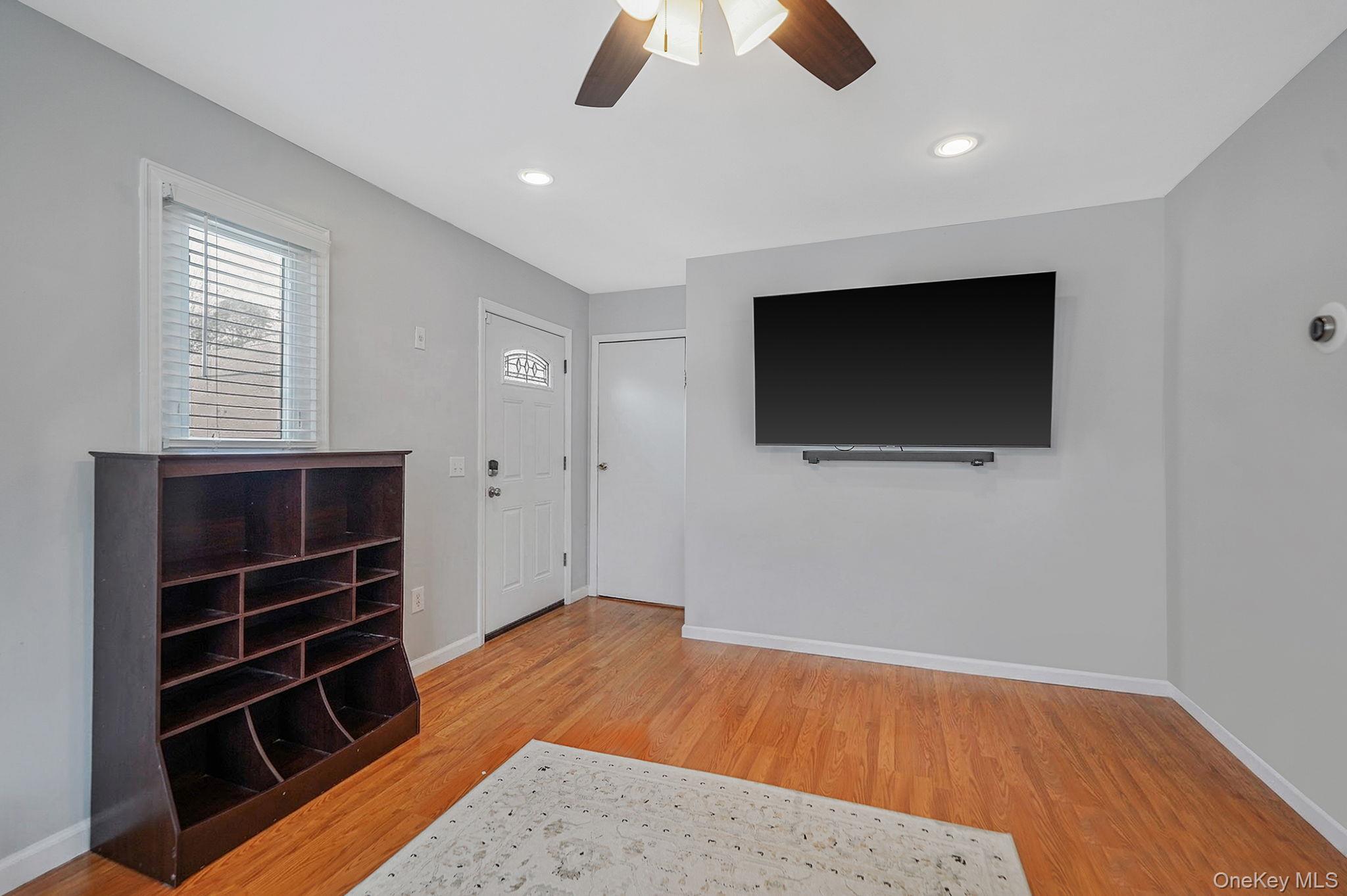 19 Goodwin Lane Coram, NY 11727 - Photo 10 of 36 a view of an empty room with wooden floor and a window