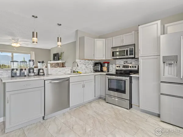 a kitchen with white cabinets and white appliances