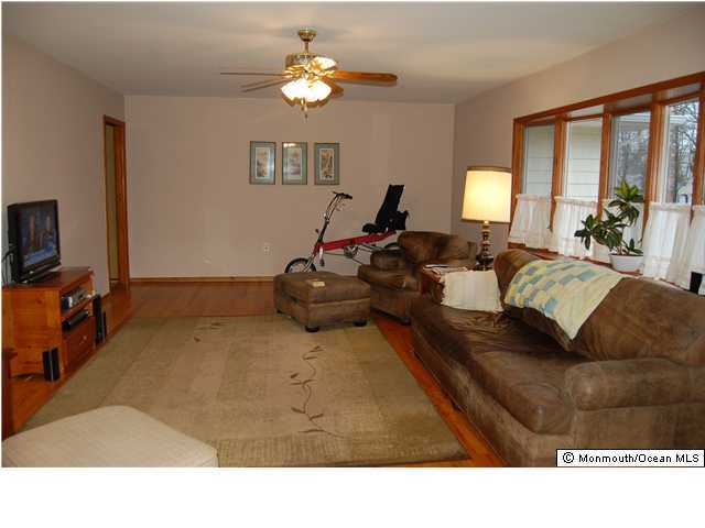 128 North Cooks Bridge Road Jackson, NJ 08527 - Photo 3 of 3 a living room with furniture a chandelier and a flat screen tv