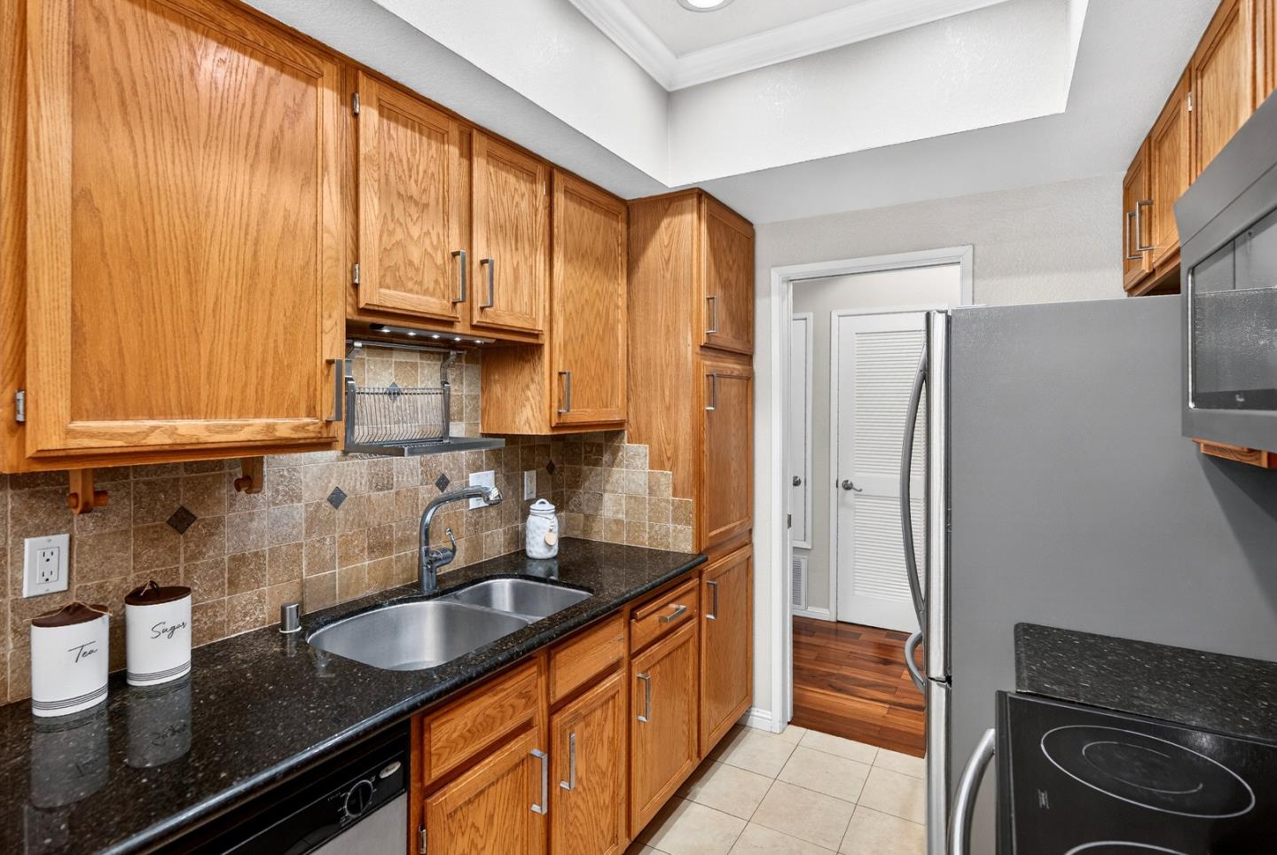 22330 Homestead Road, Unit 214 Cupertino, CA 95014 - Photo 5 of 35 a kitchen with granite countertop a sink stove and refrigerator