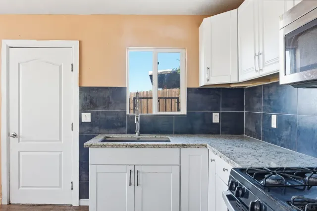 a kitchen with stainless steel appliances granite countertop a sink and a stove