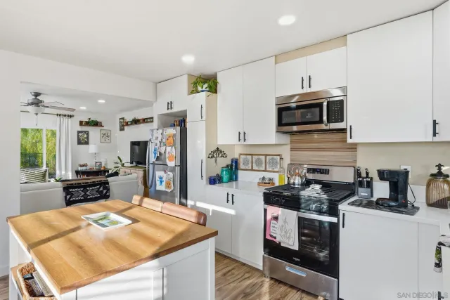 a kitchen with stainless steel appliances kitchen island granite countertop a stove refrigerator and a microwave