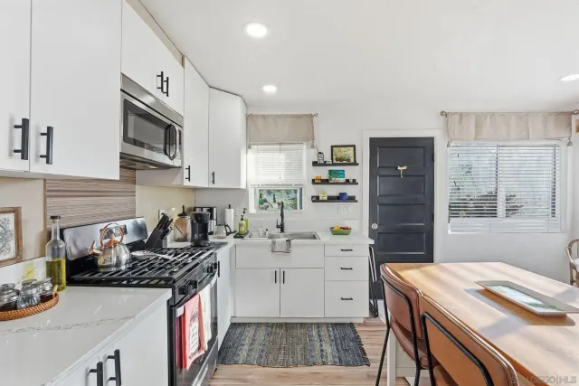 a kitchen with granite countertop a sink stove and cabinets