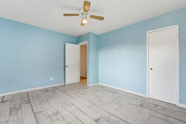 an empty room with closet and fan