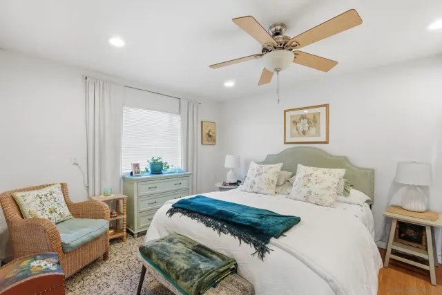 a bedroom with a bed couches and window