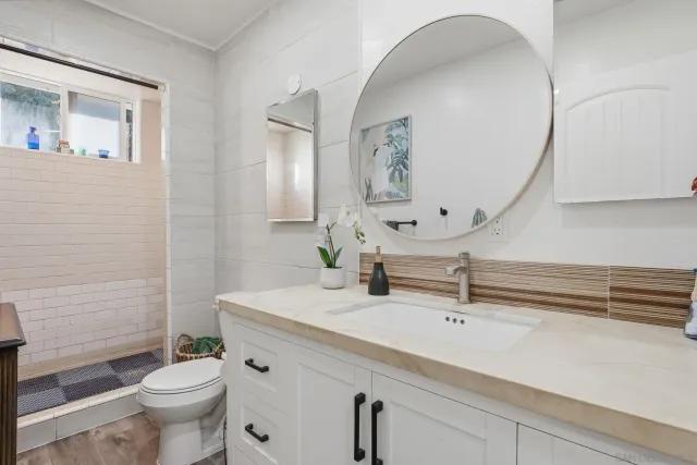 a bathroom with a sink a toilet and a mirror