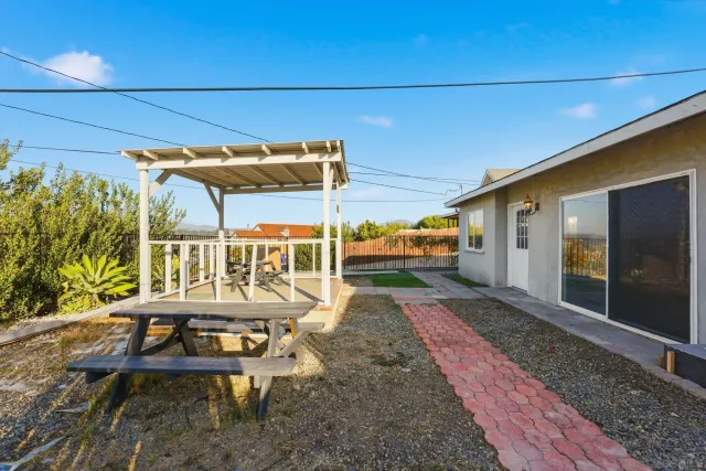 a view of a patio with table and chairs with wooden floor and fence