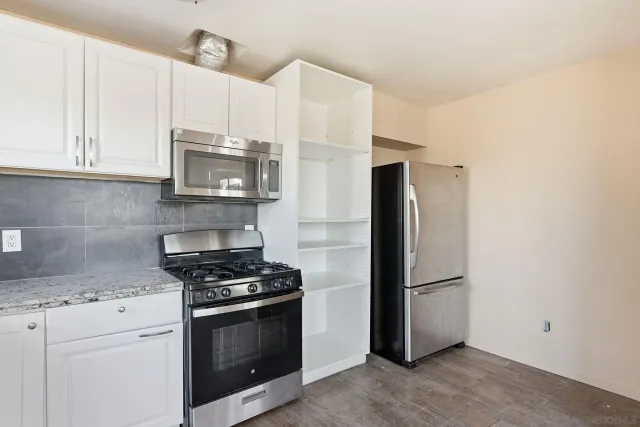 a kitchen with stainless steel appliances white cabinets and a granite counter tops
