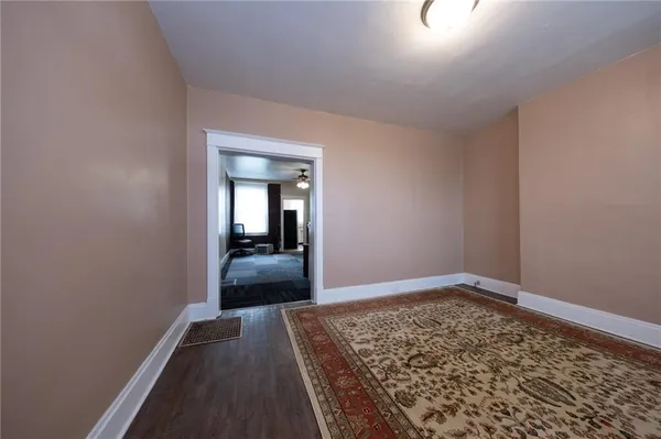 a view of hallway with a large mirror and a wooden floor