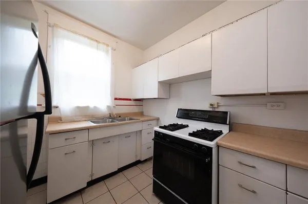 a kitchen with cabinets appliances a sink and a window