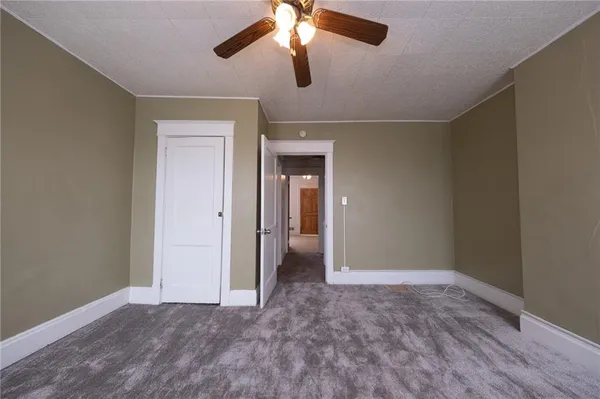 a view of empty room with window and ceiling fan
