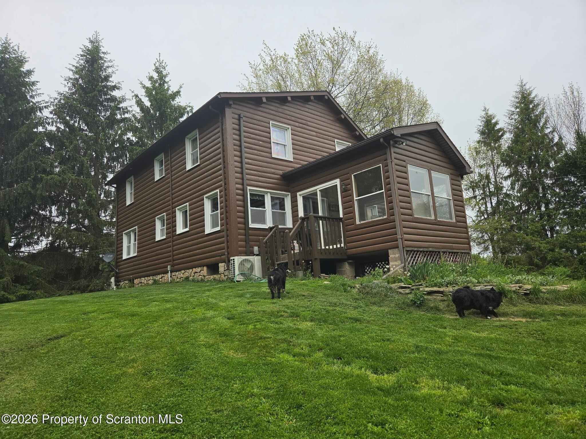 2590 Potter Hill Road Thompson, PA 18465 - Photo 4 of 43 a front view of a house with a garden