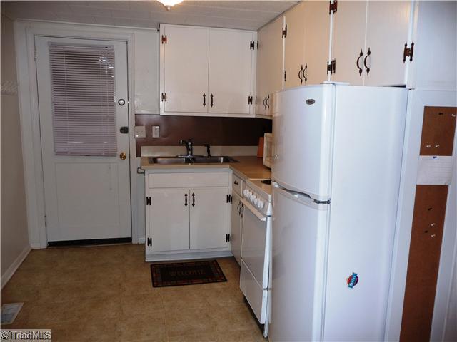 7803 Sutter Road Greensboro, NC 27455 - Photo 4 of 4 Kitchen. Copper backsplash, cork bulletin board to the side of the refrigerator---small but very functional and clean!