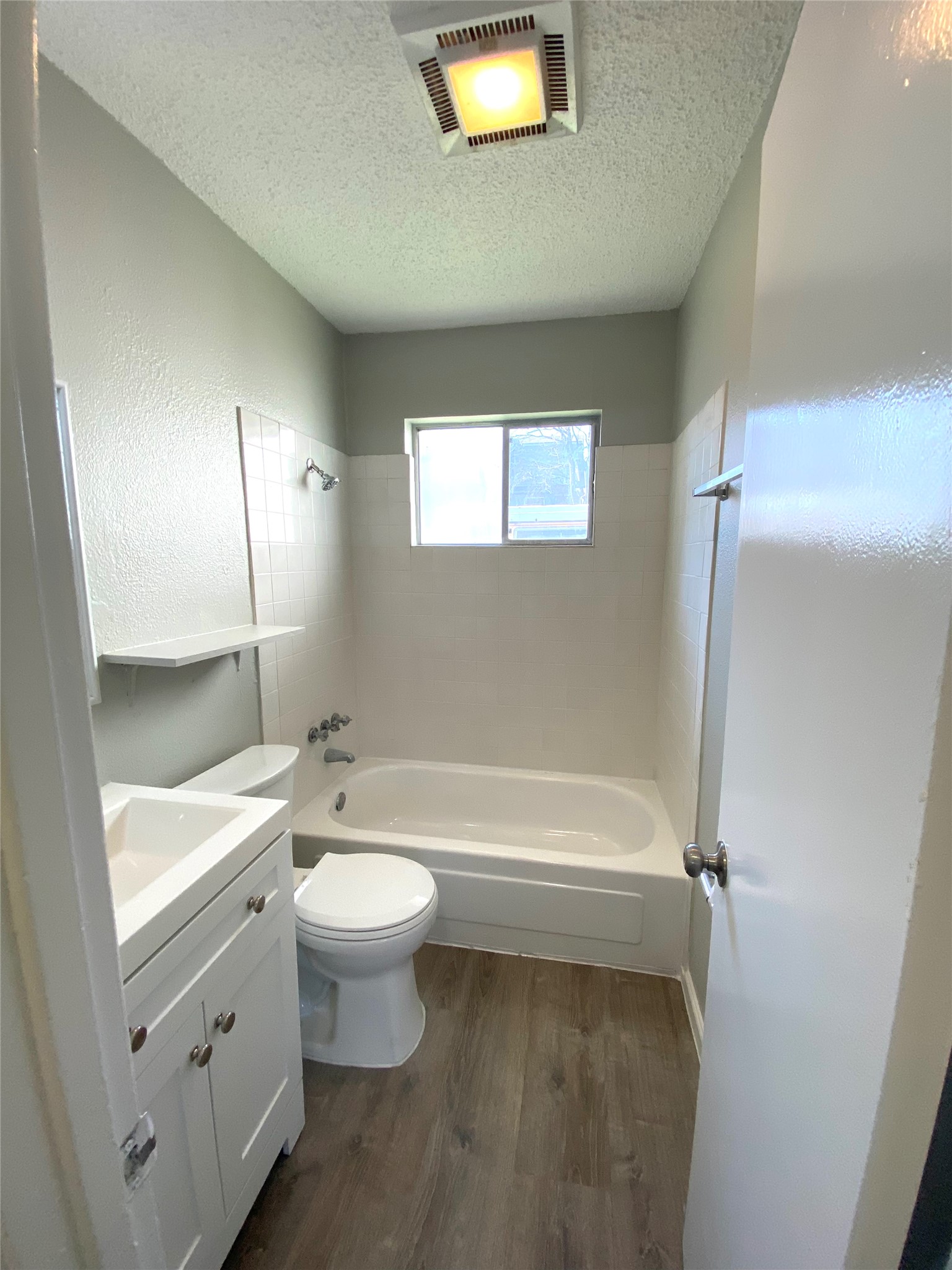 404 Swanee Drive, Unit B Austin, TX 78752 - Photo 5 of 5 Full bathroom featuring vanity, shower / bathtub combination, dark wood-style flooring, and a textured ceiling