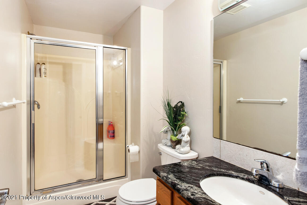 1090 Hickory Drive Rifle, CO 81650 - Photo 13 of 27 a bathroom with a granite countertop sink toilet and shower
