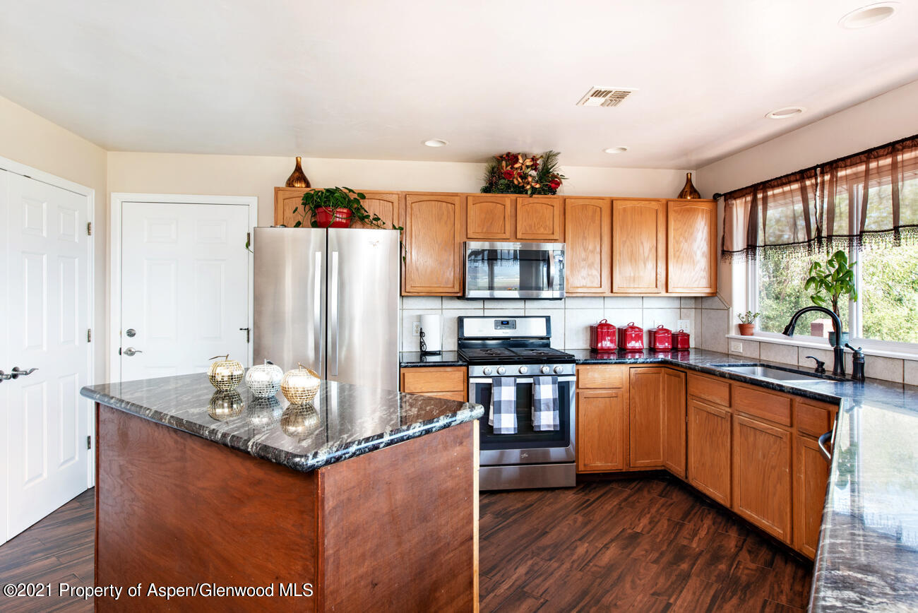 1090 Hickory Drive Rifle, CO 81650 - Photo 6 of 27 a kitchen with granite countertop a sink cabinets and stainless steel appliances