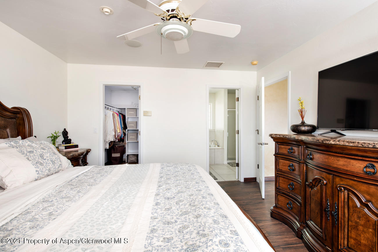 1090 Hickory Drive Rifle, CO 81650 - Photo 8 of 27 a bed room with a bed and a flat tv screen on a dresser