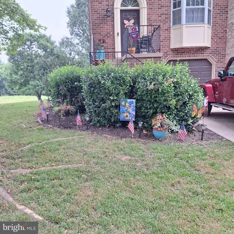 a view of a backyard with plants and a table and chair