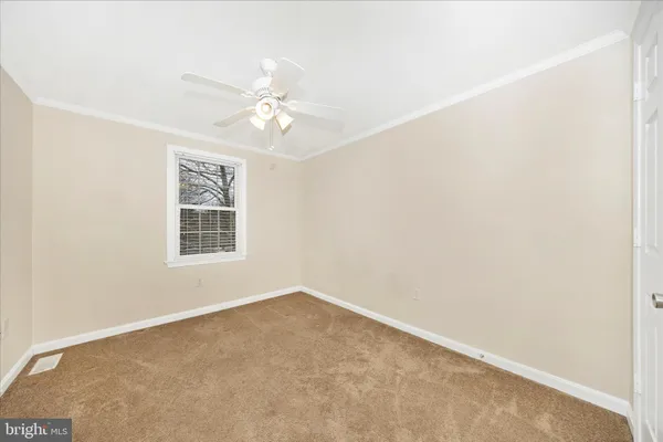 an empty room with a ceiling fan and a window
