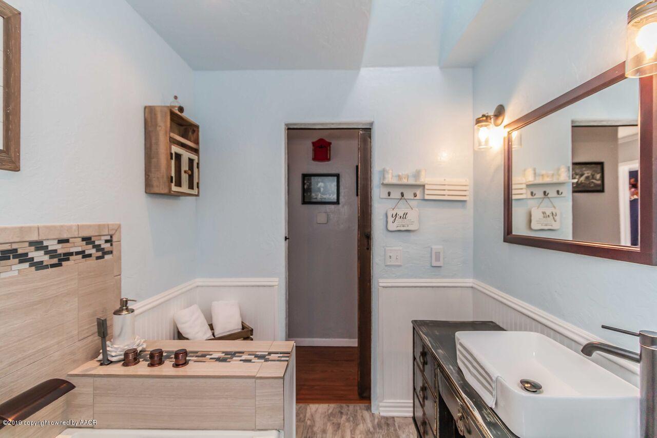 4709 Journey Street Amarillo, TX 79110 - Photo 26 of 43 a bathroom with a tub sink and mirror