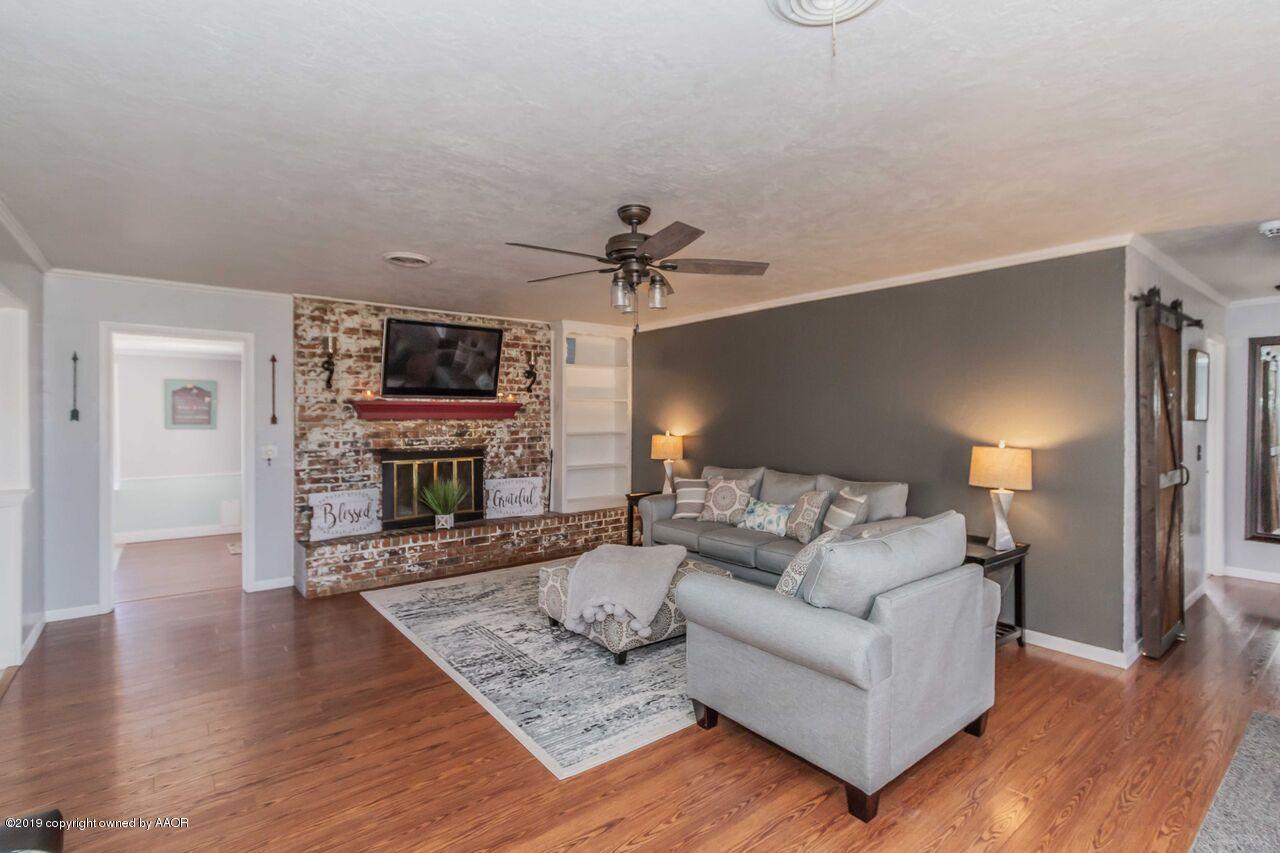 4709 Journey Street Amarillo, TX 79110 - Photo 8 of 43 a living room with furniture a fireplace and a flat screen tv