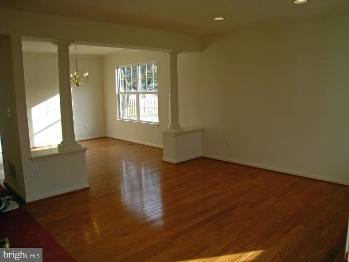 8012 Clark Station Road Severn, MD 21144 - Photo 4 of 8 an empty room with wooden floor and windows