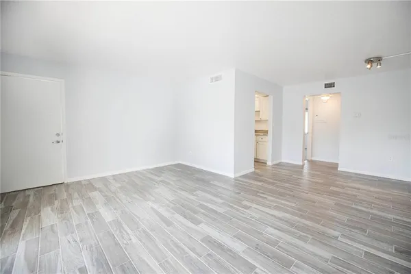 a view of empty room with wooden floor