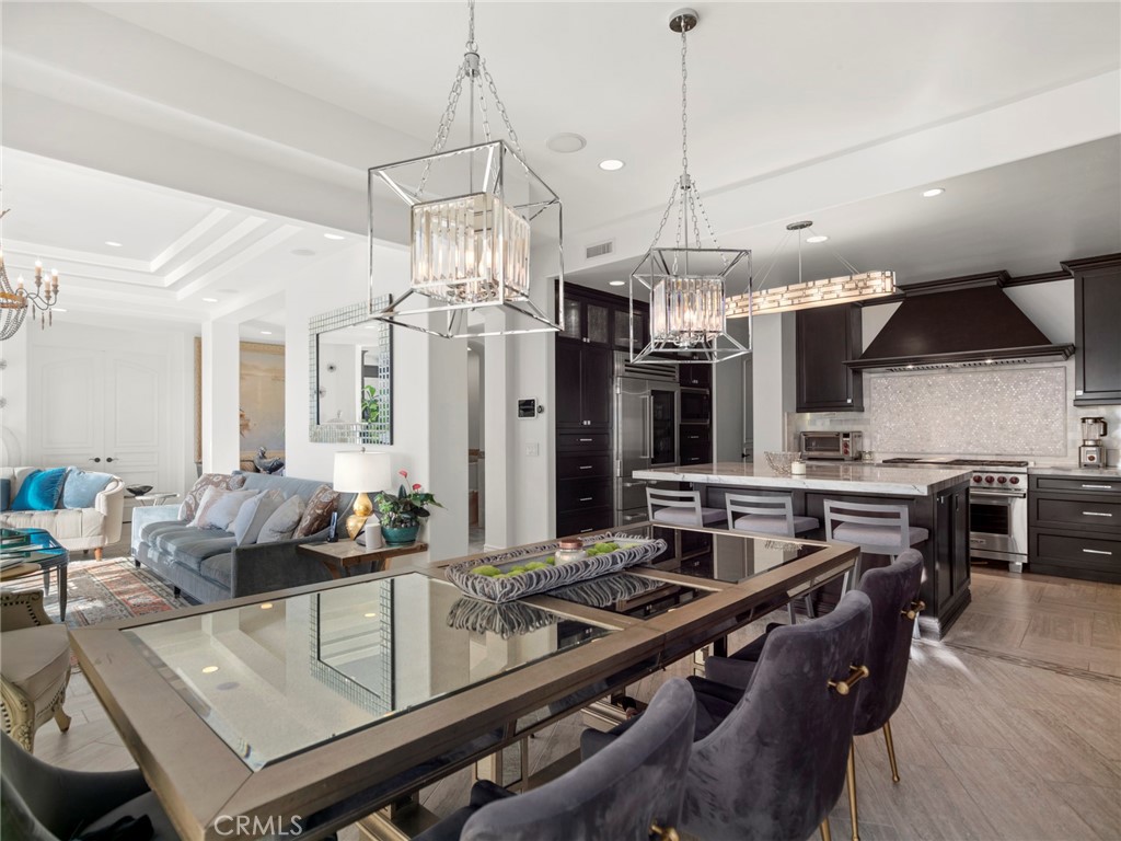 4 Peninsula Newport Coast, CA 92657 - Photo 7 of 20 a kitchen with a stove a kitchen island a sink and chairs