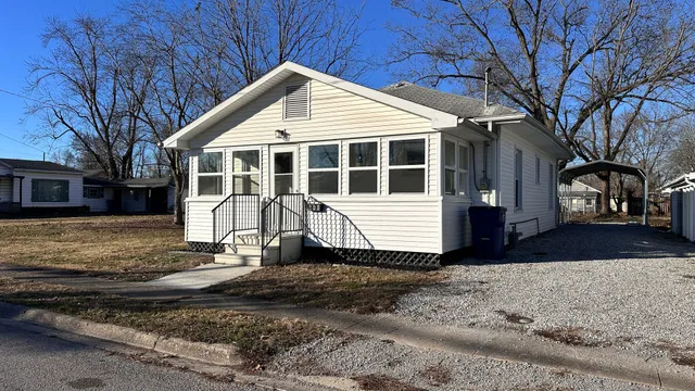 a front view of a house with a yard covered with snow