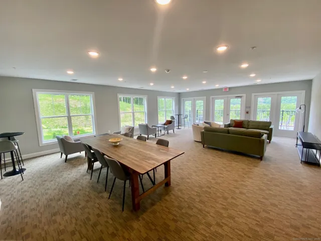a living room with furniture a large window and a table