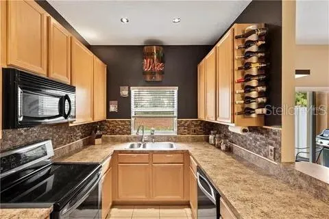 a kitchen with stainless steel appliances granite countertop a sink stove and microwave