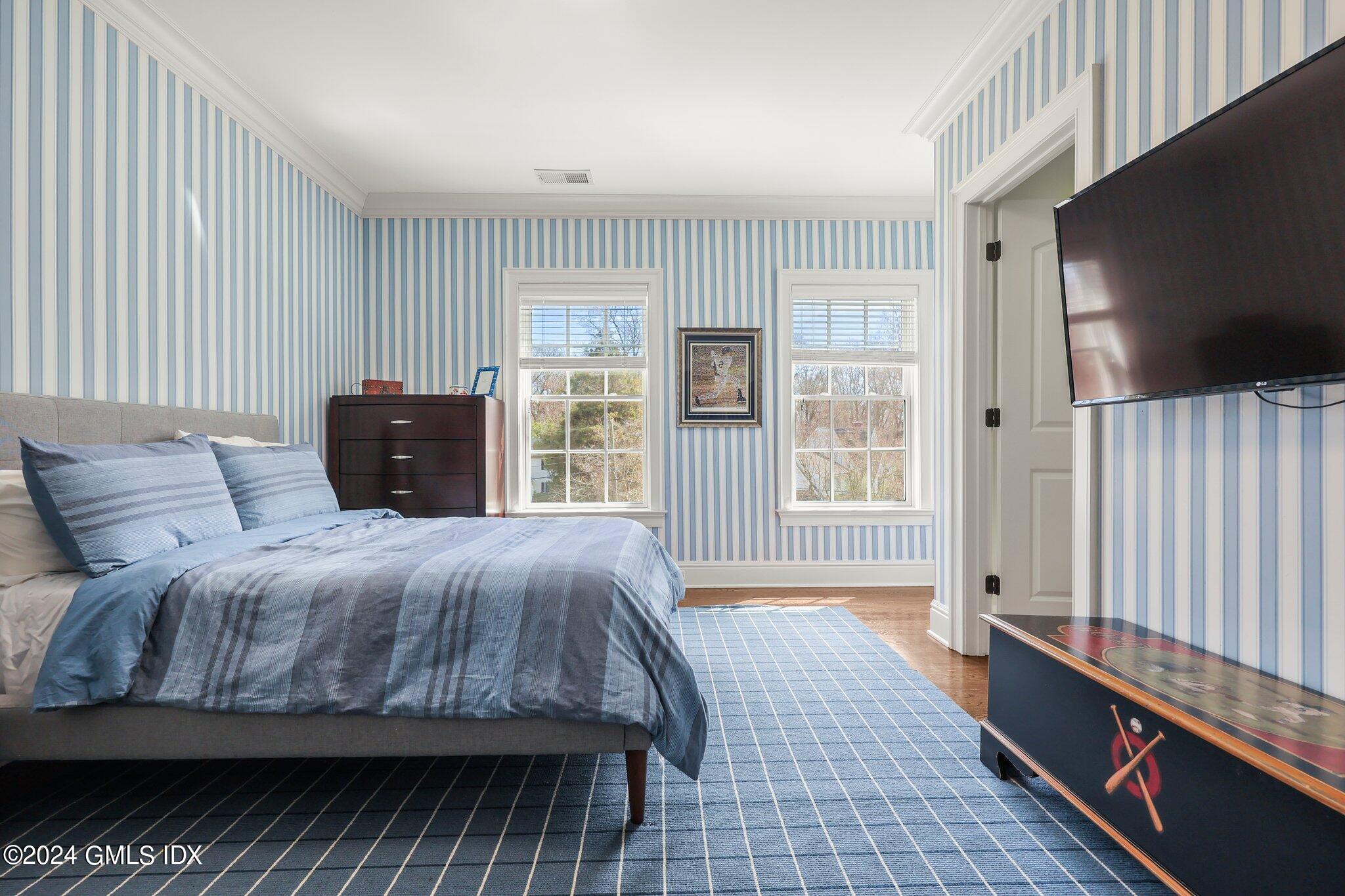 6 Coachlamp Lane Greenwich, CT 06830 - Photo 24 of 33 a bedroom with a large bed and a flat tv screen