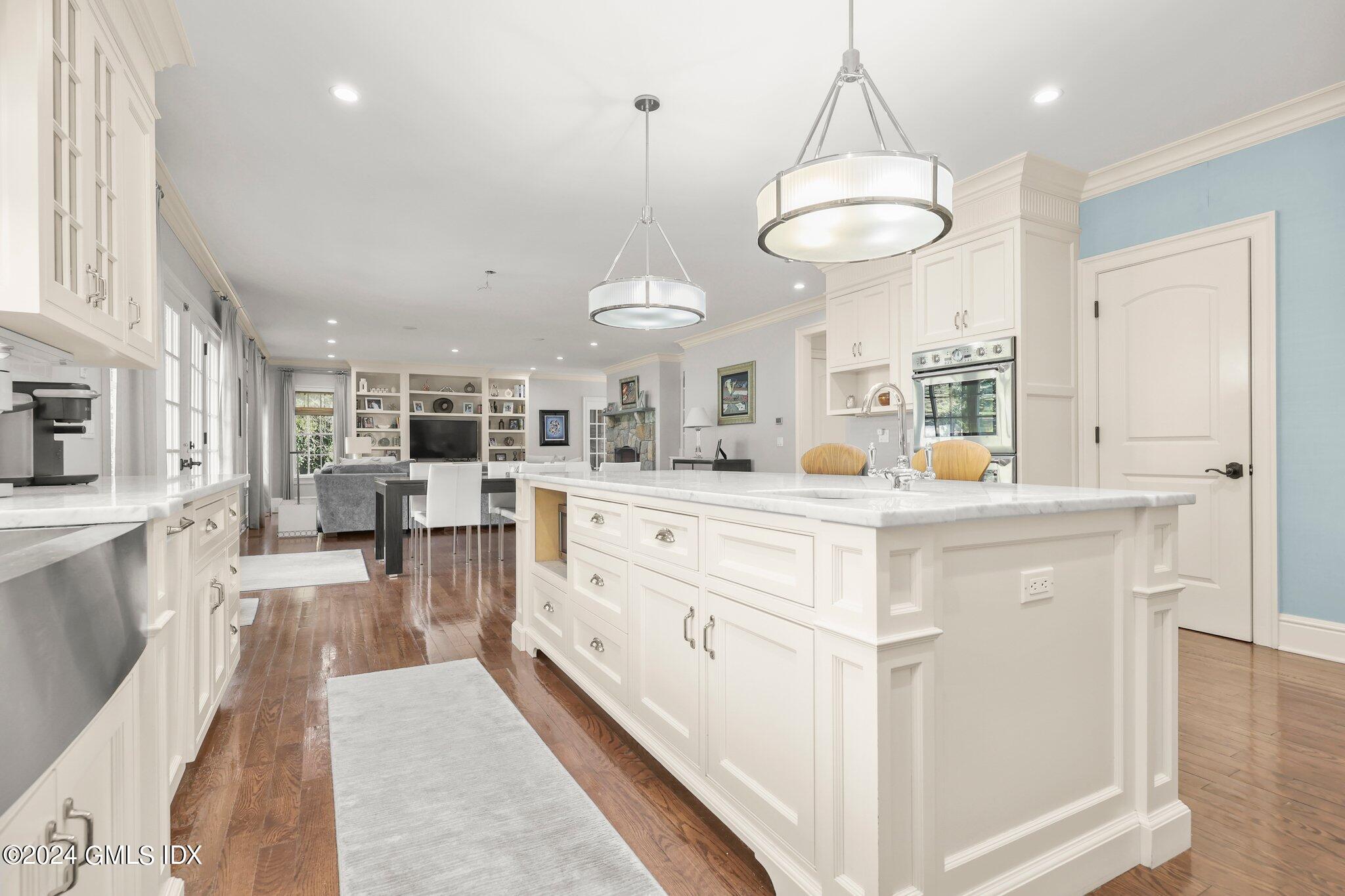 6 Coachlamp Lane Greenwich, CT 06830 - Photo 10 of 33 a large white kitchen with a refrigerator a stove and a chandelier