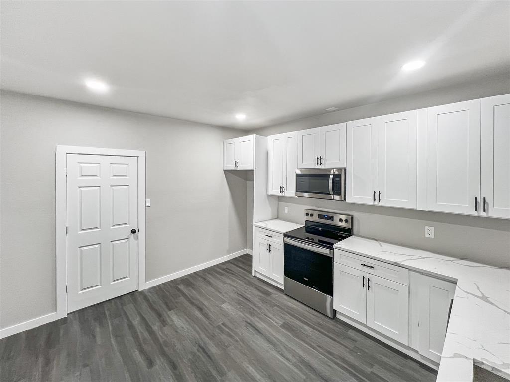 5530 Reiger Avenue, Unit 5528 Dallas, TX 75214 - Photo 23 of 40 a kitchen with granite countertop white cabinets and stainless steel appliances