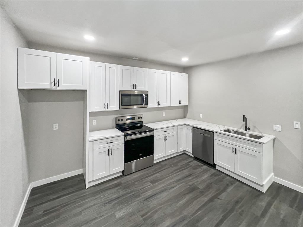 5530 Reiger Avenue, Unit 5528 Dallas, TX 75214 - Photo 24 of 40 a kitchen with cabinets stainless steel appliances a sink and wooden floor