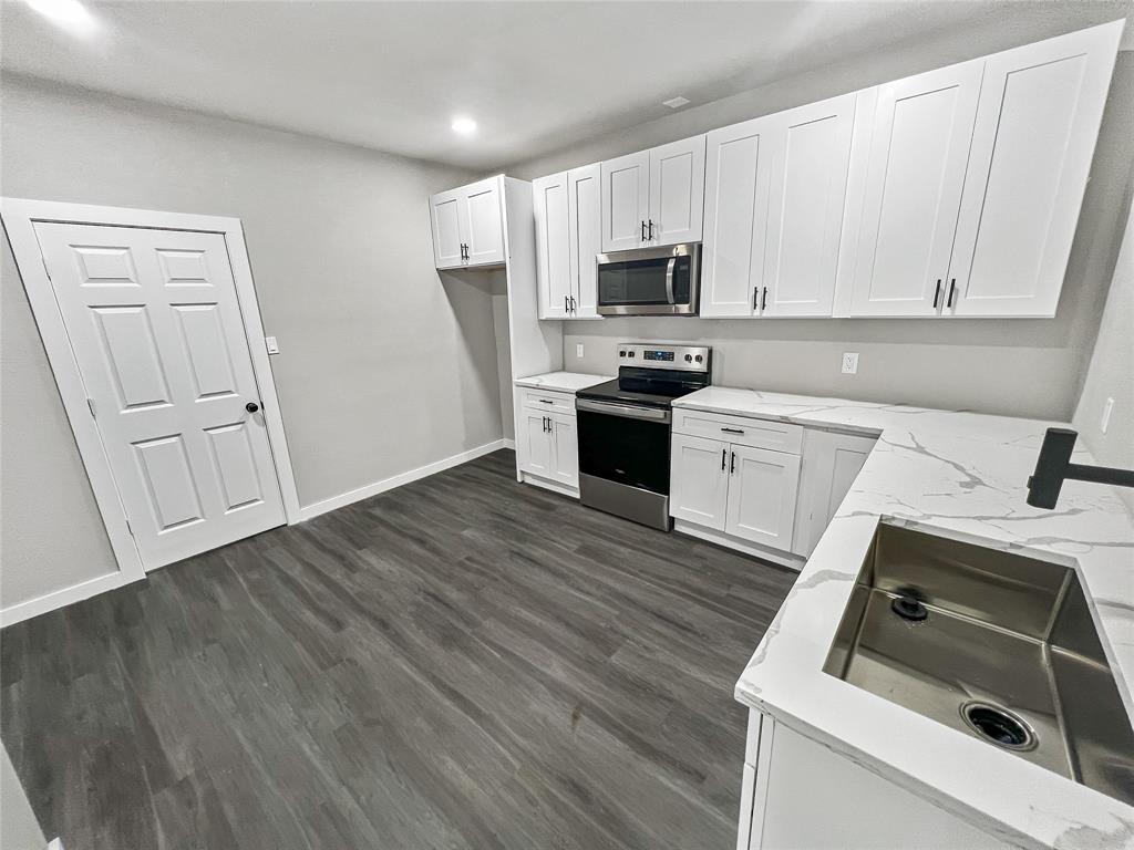 5530 Reiger Avenue, Unit 5528 Dallas, TX 75214 - Photo 25 of 40 a kitchen with granite countertop white cabinets sink and stainless steel appliances