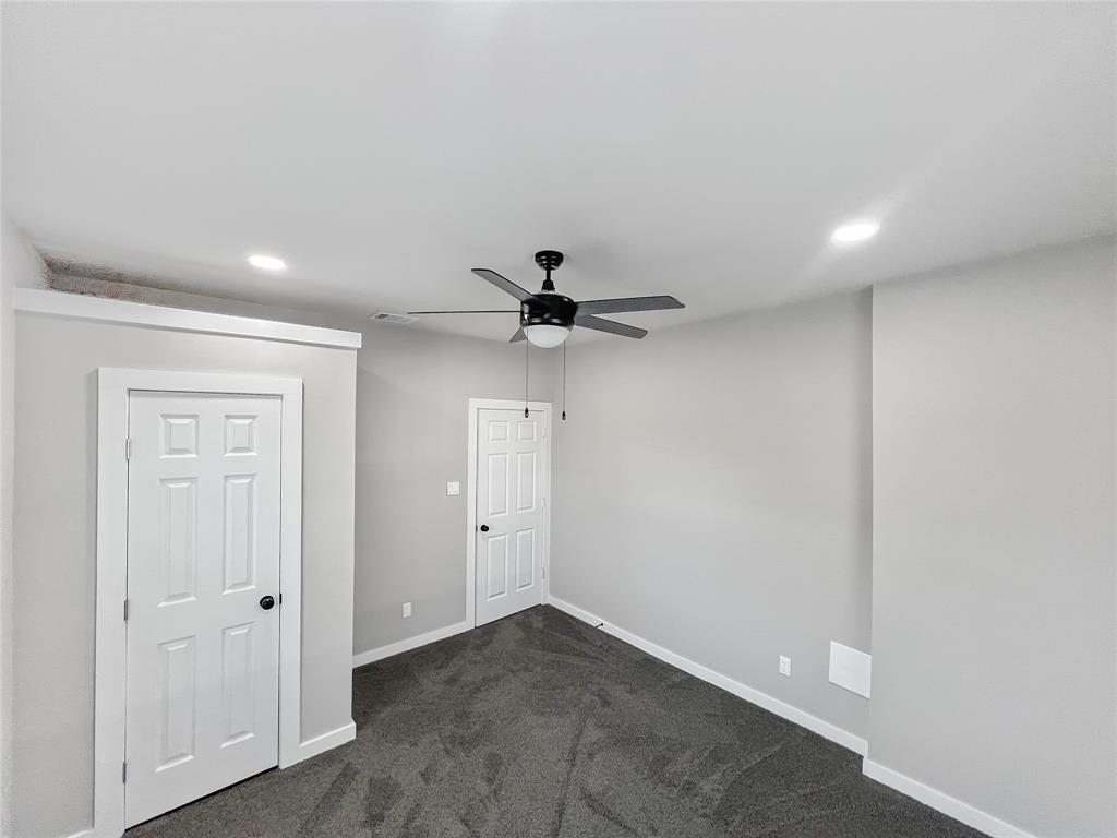 5530 Reiger Avenue, Unit 5528 Dallas, TX 75214 - Photo 31 of 40 an empty room with a ceiling fan and carpet