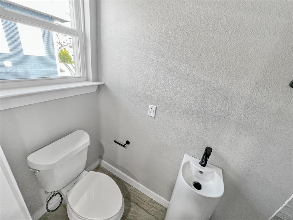 5530 Reiger Avenue, Unit 5528 Dallas, TX 75214 - Photo 32 of 40 a white toilet sitting next to a bathroom sink