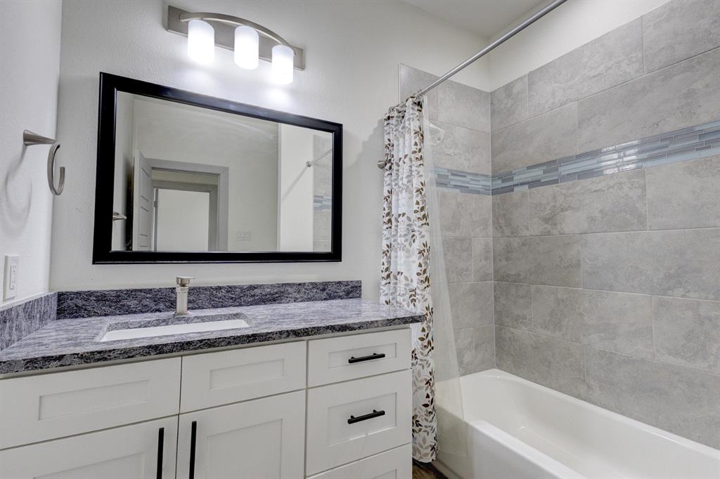6043 Rivendell Drive Frisco, TX 75035 - Photo 27 of 38 a bathroom with a sink double vanity granite tub shower and a mirror