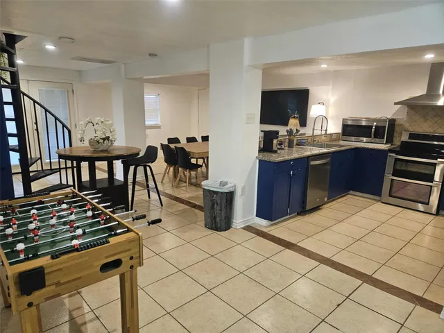 a kitchen with stainless steel appliances kitchen island granite countertop a sink and cabinets